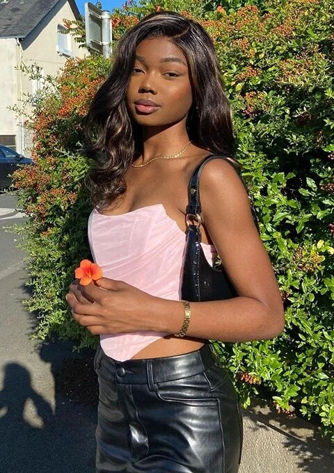 Femme portant un top bustier rose avec un sac à main