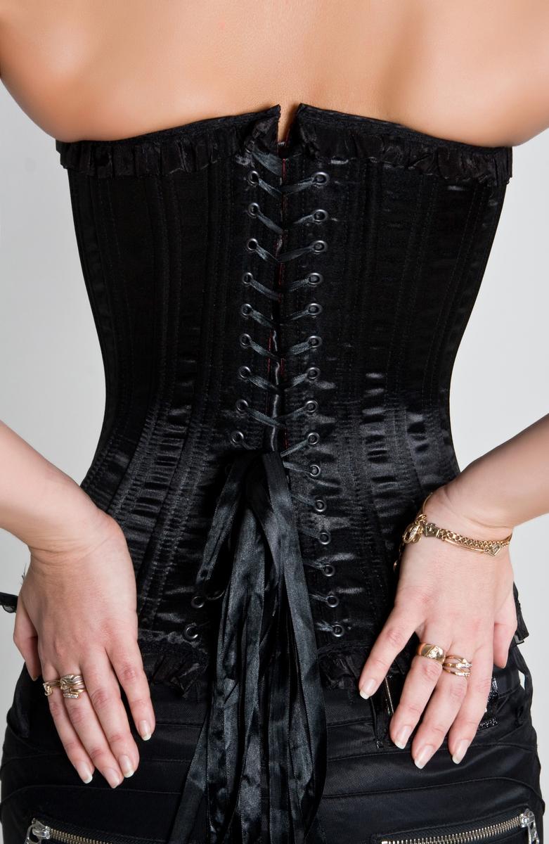 Femme portant un corset noir lacé vue de dos