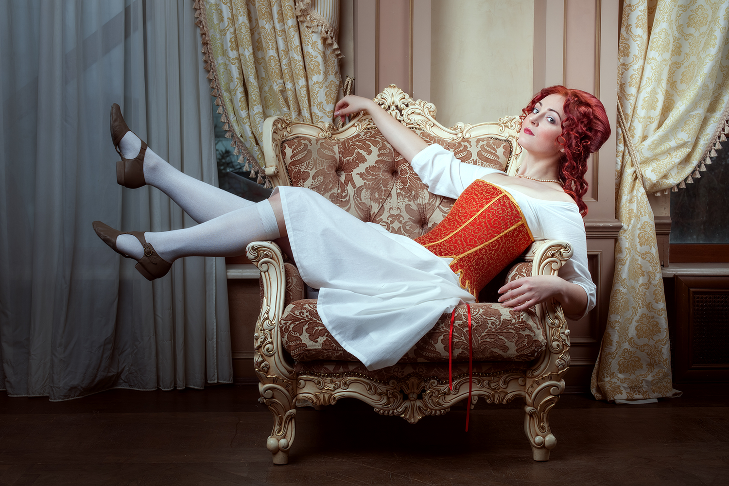 Femme assise dans un fauteuil portant un corset rouge